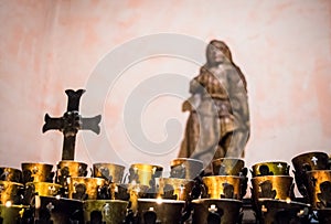 Prayer candles in Catholic Church with crucifix and symbolism