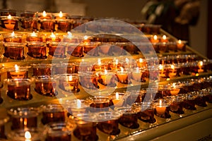Prayer candles light up the darkness in a church