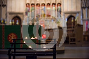 Prayer candles lit inside a church as a votive offering in an act or prayer