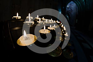 Prayer candles shine bright in a dark cathedral
