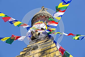 Prayer colorful flags flying from the Buddhist Stupa, a place of holy worship. Buddhist Temple in the Kathmandu valley, Nepal