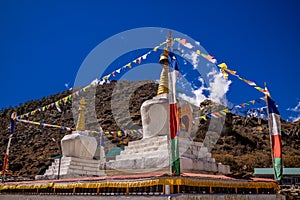 Prayer flags on big stupa with buddha eyes in Nepal Himalaya village Namche Bazar
