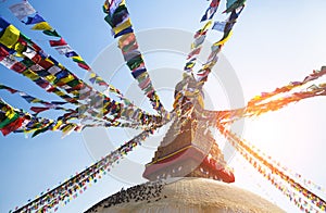 Prayer flags flying against the sun from the Boudhanath Stupa