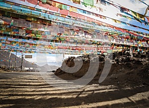 Prayer flags spanning a road on a mountain pass, Tibet