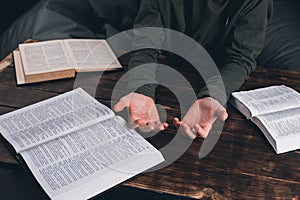 Prayer. A group of Christians pray holding hands. On the table. The Holy Bible is open. Praying