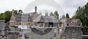 Prayer hall out of focus in the distance. Gravestones in focus in the foreground at historic Willesden Jewish Cemetery, north west