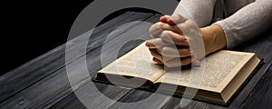 Prayer hand on Bible book on dark room