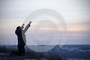 Prayer. A man on his knees. With your hands up. Glorification of God. Glory to God.