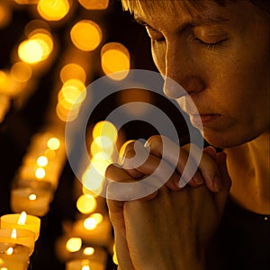 Prayer praying in Catholic church near candles