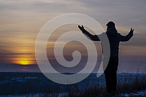 Prayer. Repentance. A man with his hands raised against the sky. Pray to God. Worship, against the backdrop of sunset