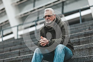 Prayer to God. An elderly man sits outdoors hoping. Thinks alone, depressed