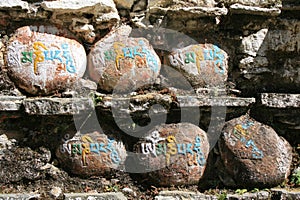 prayers on rocks in a buddhist temple (kurjey lhakhang) in jakar (bhutan)