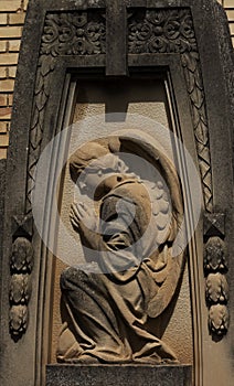 Praying angel framed under the cross photo