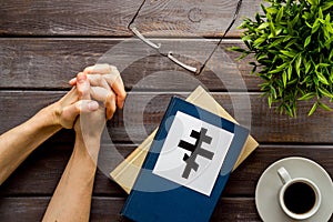 Praying concept with hands, Holy Bible, Ortodox cross on wooden background top-down. Copy space