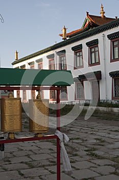 Praying cylinders and white building. Gandantegchinlen Monastery, Mongolia