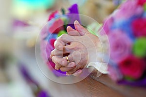 Praying hands at alter during church wedding