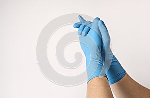 Praying hands in blue rubber gloves, close-up