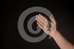 Praying hands with Celtic Cross in hand, asking for help