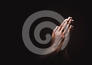 Praying hands with faith in religion and belief in God on dark background. Power of hope or love and devotion. Namaste or Namaskar