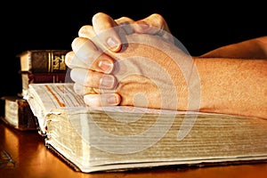 Praying Hands in Light with Holy Bibles