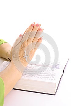 Praying hands over bible with rhinestone cross