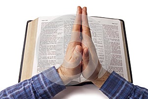 Praying hands over open bible