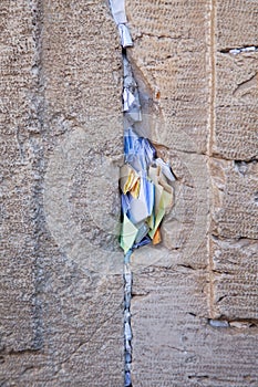 Praying notes in a gap of the wailing wall in vertical view