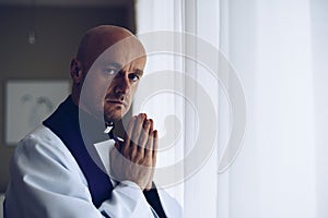 Praying priest with folded hands