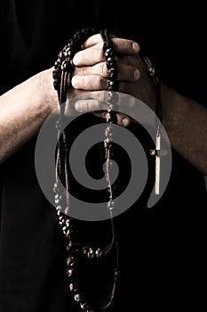 Praying priest with rosary beads