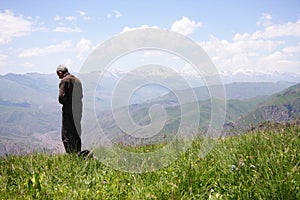 Praying senior in mountains