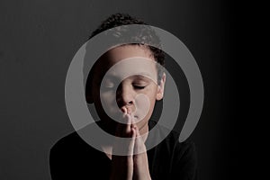 Praying to God with hands together with black background with people stock photo