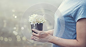 Praying woman with white bouquet in hands to show respectt, filt