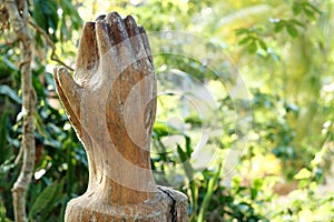 Praying Wooden Hands on green nature background. Religion spirituality belief and hope.