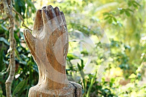 Praying Wooden Hands on green nature background. Religion spirituality belief and hope. photo