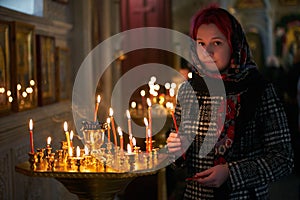 Praying young woman with candle