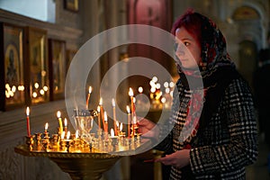 Praying young woman with candle