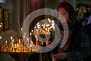 Praying young woman with candle