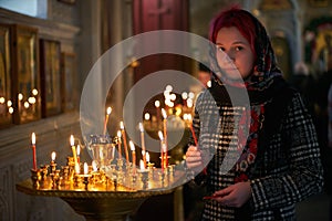 Praying young woman with candle