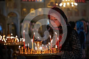 Praying young woman with candle