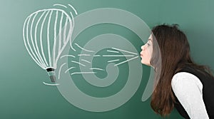 Pre-adolescent girl blowing on painted balloon aeronautics photo