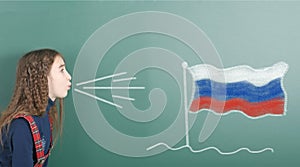 Pre-adolescent girl blowing on Russian Federation flag