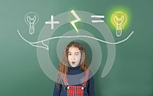 Pre-adolescent girl stands behind chalk-painted light bulb