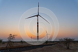 Pre dawn light in desert sky with Electrical power generating wind mills producing alterative eco friendly green energy for