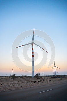 Pre dawn light in desert sky, with Electrical power generating wind mills producing alterative eco friendly green energy for