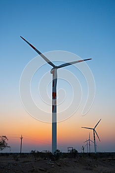 Pre dawn light in desert sky with Electrical power generating wind mills producing alterative eco friendly green energy for