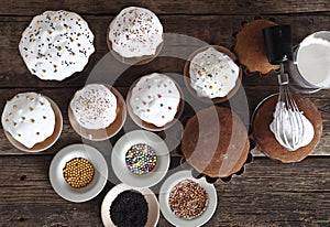 Pre holiday chores. Homemade Easter pastries with festive sprinkles for baking are displayed on a wooden background