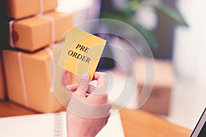 `Pre-Order` text on post it paper in woman hand at post office with many boxes, Online shopping and Marketing concept idea. Split photo
