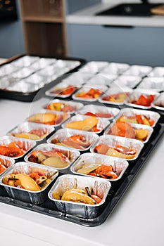 Pre-portioned Gourmet Roasted Bell Peppers in Trays. Close-up view of vibrant roasted bell peppers portioned in aluminum