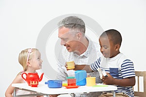 Pre School Children Enjoying Tea Party With Teacher