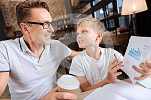 Pre-teen boy asking his father about charts on printout